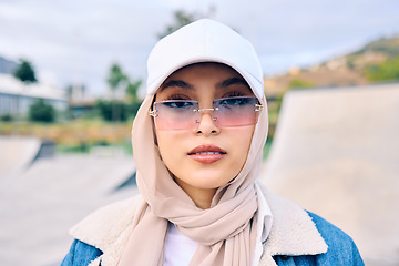 Image showing Portrait, fashion or sunglasses with a muslim woman outdoor in a cap and scarf for contemporary style. Islam, faith and hijab with a trendy young arab female person posing outside in modern eyewear