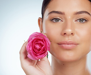 Image showing Skincare, face and woman with rose in studio isolated on a white background. Portrait, natural flower and serious female model with pink floral plant for makeup cosmetics, beauty treatment or organic