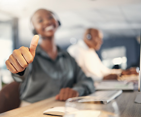 Image showing Thank you, African woman with thumbs up and headset at her workplace in a office for success. Congratulations or support, telemarketing or crm and call center agent with emoji hand for motivation