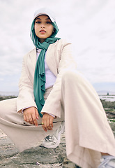 Image showing Portrait, fashion or religion with a muslim woman outdoor in a cap and scarf for contemporary style. Islam, faith and hijab with a trendy young arab female person posing outside in modern clothes