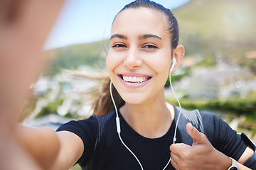 Image showing Runner woman, mountain selfie and portrait for energy, smile and fitness training for wellness on social media. Girl, influencer and profile picture with ocean, cityscape and thumbs up with music