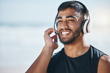 Image showing Happy, beach and a man with music for fitness, running motivation and ideas in nature. Smile, wellness and an athlete listening or streaming a podcast while training or exercise vision at the sea