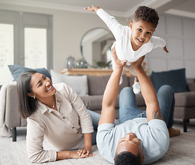 Image showing Happy family, kids and flying games in home on living room floor for fun, quality time and relax. Mom, dad and holding boy child in air for play, happiness and support of parents on carpet in lounge