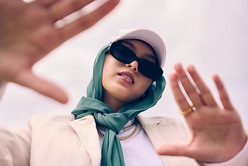 Image showing Low angle portrait, woman and city for muslim fashion with gen z aesthetic, streetwear and sky background. Young islamic girl, student and clothes with sunglasses, freedom and outdoor travel in Dubai