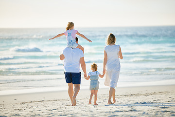 Image showing Summer, holding hands and travel with family at beach for happy, vacation and bonding. Freedom, support and ocean with parents and children walking on seaside holiday for love, care and happiness