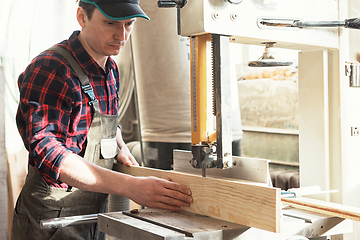 Image showing Carpenter worker cutting wooden board