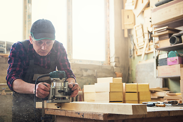 Image showing Worker grinds the wood box