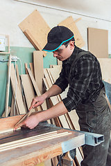 Image showing Carpenter worker cutting wooden board