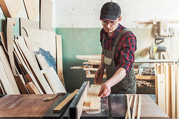 Image showing Carpenter worker cutting wooden board