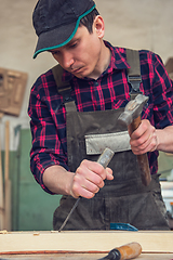 Image showing Carpenter working with a chisel