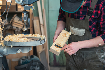 Image showing Carpenters with electric drill machine drilling wooden board