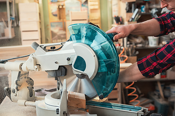 Image showing Carpenter worker cutting wooden board