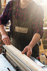 Image showing The worker makes measurements of a wooden board