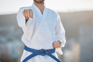 Image showing Karate, fitness and fighting with a sports man in gi, training in the city on a blurred background. Exercise, discipline or strong with a male athlete during a self defense workout for health closeup