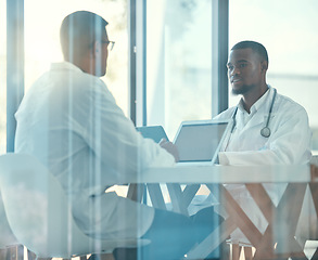 Image showing Meeting room, laptop and team of doctors for healthcare coworking, discussion and planning or teamwork. Working, talking and medical people on computer, telehealth and research behind a glass window