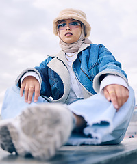 Image showing Portrait, fashion or sunglasses with a muslim woman in the city wearing a cap and scarf for contemporary style. Islam, faith and hijab with a trendy young arab person posing outside in modern eyewear