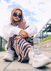 Image showing Portrait, fashion or hijab with an islam woman outdoor in sunglasses and scarf for contemporary style. Arab, faith or burka with a trendy young muslim person outside in a city wearing modern clothes