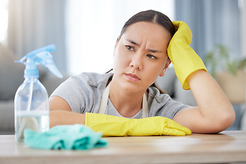 Image showing Thinking, annoyed and cleaning with a woman housekeeper using disinfectant to remove bacteria in a home. Idea, frustrated and hygiene with a young female cleaner working in a living room for service