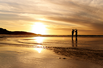 Image showing Couple, sunset and dancing by ocean with space for mockup in summer sunshine with love, care and dance on holiday. Man, woman and dance with sky background, beach and clouds on romantic vacation