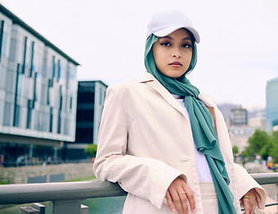 Image showing Portrait, city fashion or religion with an islamic woman outdoor in a cap and scarf for contemporary style. Arabic, faith or hijab with a trendy young muslim person posing outside in urban clothes