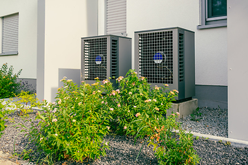 Image showing Modern air source heat pumps installed outside of new and modern city house