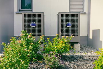 Image showing Modern air source heat pumps installed outside of new and modern city house