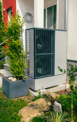 Image showing Modern air source heat pump installed outside of new city house
