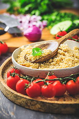 Image showing Preparing traditional oriental salad Tabouleh with couscous or bulgur, ingredients on cutting board