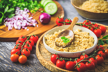 Image showing Preparing traditional oriental salad Tabouleh with couscous or bulgur, ingredients on cutting board