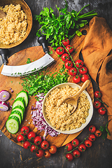 Image showing Preparing traditional oriental salad Tabouleh with couscous or bulgur, ingredients on cutting board