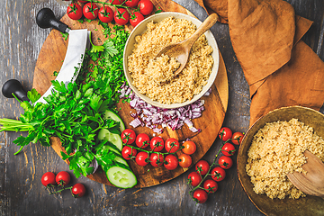 Image showing Preparing traditional oriental salad Tabouleh with couscous or bulgur, ingredients on cutting board