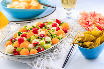 Image showing Summer light food. Cucumber and melon salad  with raspberries an