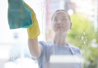 Image showing Wipe, window and cleaning with a woman housekeeper using disinfectant to remove bacteria in a home. Safety, glass and hygiene with a young female cleaner working in a domestic house for service