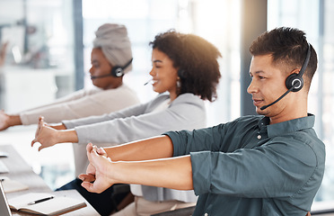 Image showing Call center, headset and team stretching at desk while tired or to start telemarketing work. Diversity women and a man together at a desk to exercise for crm, customer service and help desk support