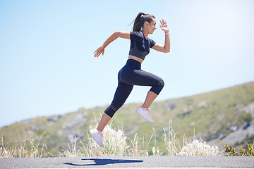 Image showing Runner woman, street and jump with speed in nature, fitness and energy for training, wellness and healthy. Girl, fast running and air on road for self care, exercise and workout by hill in summer sun