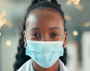 Image showing Doctor, face mask and african woman, hospital and safety from bacteria, germs and night for healthcare. Black female medic, nurse and dark clinic with headshot, vision and portrait with ppe at job