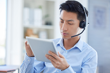 Image showing Call center, tablet and focus with asian man in office for consulting, customer service and contact us. Communication, focus and help desk with male employee for technology, digital and networking