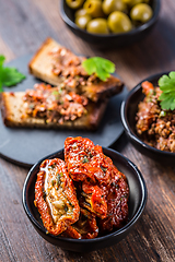 Image showing Sun dried tomatoes in olive oil and crostini with tapenade and ingredients. 