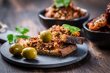 Image showing Crispy crostini with tapenade and ingredients. Tapenade - delicious olive paste, French cuisine