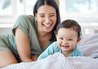 Image showing Mother, laughing baby and play on bed in home for love, care and quality time together with joy, growth and kids development. Happy mom, infant child and crawling for fun with newborn girl in bedroom