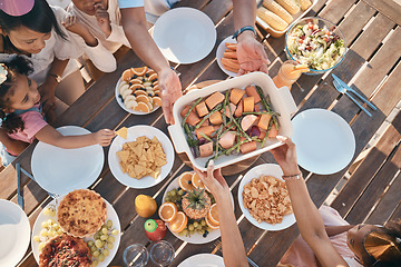 Image showing Aerial, food and family at outdoor table for birthday, celebration and party, eating together. Top view, social event and parents with children at picnic with meal, lunch and bonding to celebrate