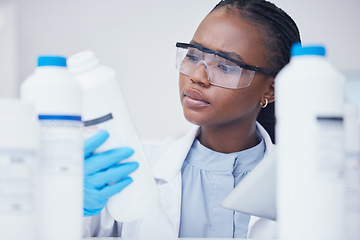 Image showing Label check tablet, chemical bottle and black woman scientist with mask at pharmaceutical lab. Research, digital reading and science of a female worker with manufacturing job and chemistry inventory