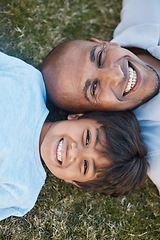 Image showing Family, portrait and lying on grass in backyard with father and kid together with love. Face, top view and dad with child on holiday with with parent support and care on a lawn with happy smile