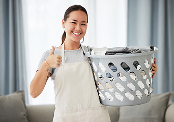 Image showing Happy asian woman, laundry and thumbs up for housekeeping, cleaning or hygiene at home. Portrait of female person, cleaner or domestic with smile and thumb emoji, yes sign or like for clean clothing