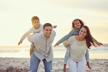 Image showing Portrait of parents piggyback kids on beach for family holiday, summer vacation and weekend. Nature, travel and happy mother, father and children playing by ocean for bonding, fun and quality time