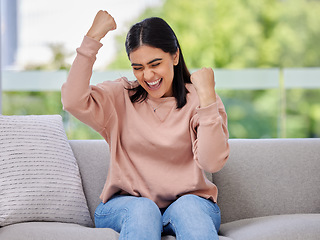 Image showing Woman, sofa and fist celebration in home living room, excited and winning with goals, motivation or prize. Girl, winner and happiness for success, celebrate and achievement on lounge couch in house