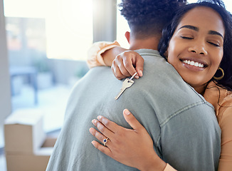 Image showing Happy couple, hug and real estate with key for moving in new home or mortgage loan together indoors. Woman hugging man with smile in happiness, property or investment with keys to apartment building