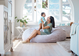 Image showing Home, mother and holding baby to relax on bean bag for love, care and quality time together in childhood development. Mom, infant and carrying newborn kid in living room for support, fun and comfort