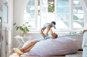 Image showing Happy mother, play and holding baby in air at home for love, care and quality time together for childhood development. Mom, infant and carrying newborn kid on bean bag, nursery room and relax for fun