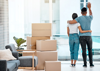 Image showing Box, hug and back of couple in new home for property, apartment and real estate investment. Relationship, house and man and woman wave hello to neighbour, embrace and boxes for moving day by a window